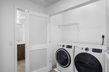 A laundry room with two front loading washing machines.